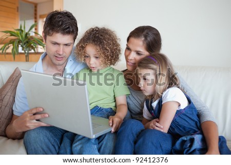 Serene family using a notebook in their living room