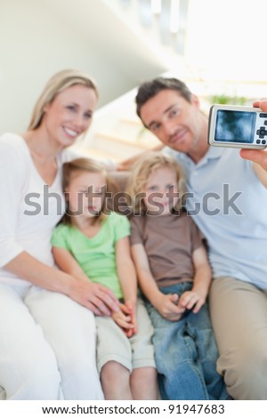 Man taking family picture on the sofa