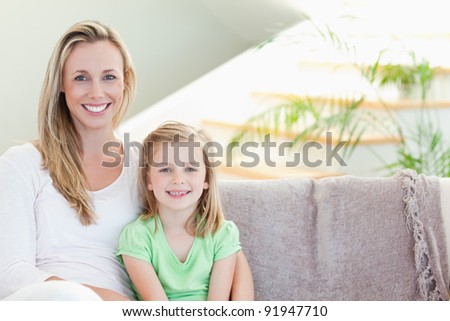 Mother and daughter sitting on the couch together