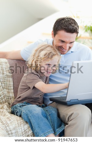 Father and son together with notebook on sofa
