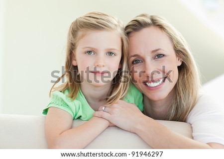 Smiling mother and daughter together on the couch