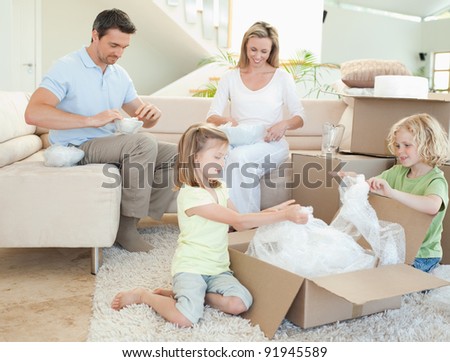 Family unpacking cardboard box together