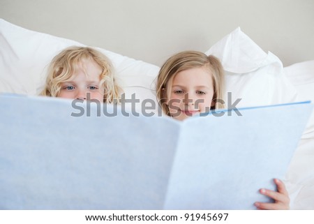 Siblings reading bedtime story together