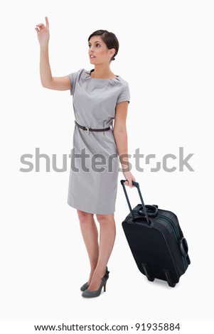 Woman with wheely bag calling a taxi against a white background