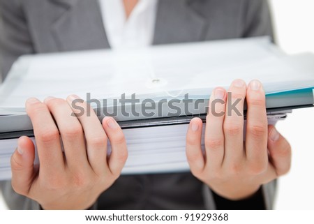 Pile of paperwork being held by female hands against a white background
