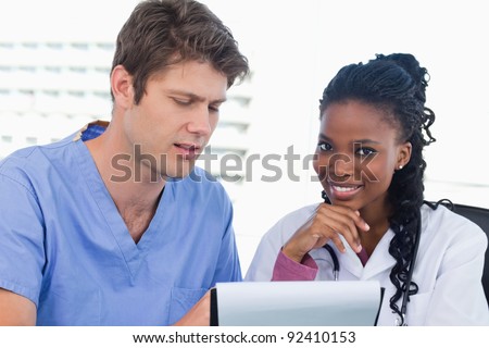 Smiling doctors looking at a document in an office