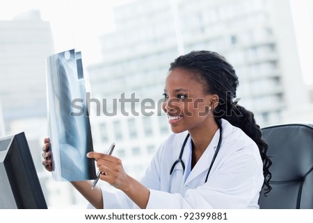 Happy female doctor looking at a set of X-rays in her office