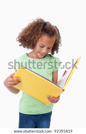 Portrait of a girl reading a fairy tale against a white background