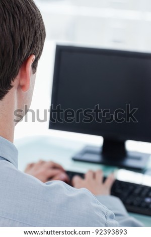 Back view of a businessman using a computer in his office
