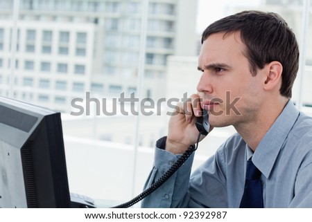 Serious office worker on the phone in his office
