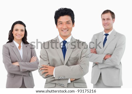 Smiling salesteam with arms folded against a white background