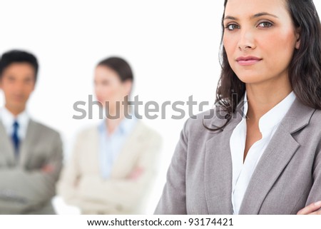 Confident businesswoman with colleagues behind her against a white background