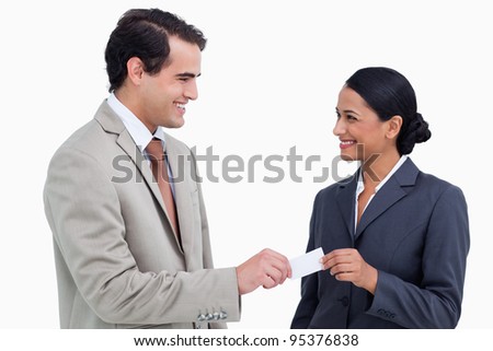 Smiling business people exchanging business cards against a white background