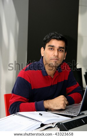 Young Indian student working on his laptop in the university.