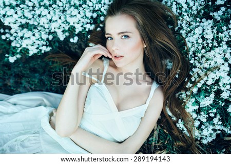 Beautiful sensual girl lying on flower meadow