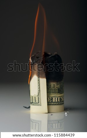 dollar note burning in fire on black background