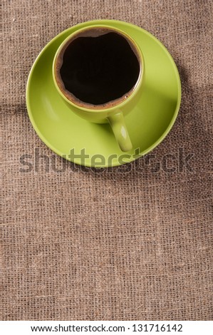 Green coffee cup on tissue background