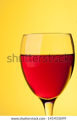 Glass of red wine on yellow background