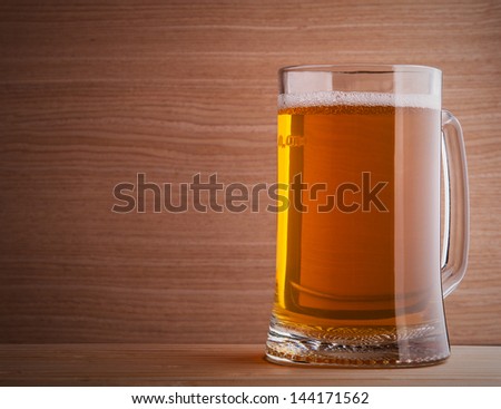 Mug of beer on wooden background