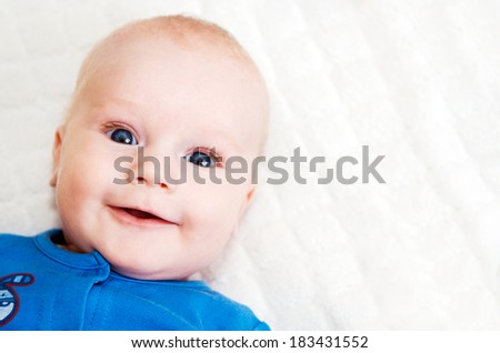 Beautiful smiling baby on soft cover