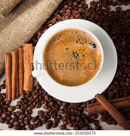 Coffee cup with roasted beans and cinnamon