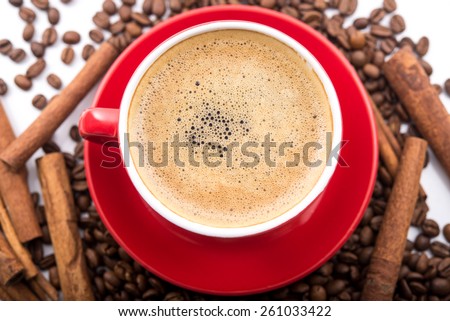 Cup with coffee and milk, roasted beans, cinnamon, on background