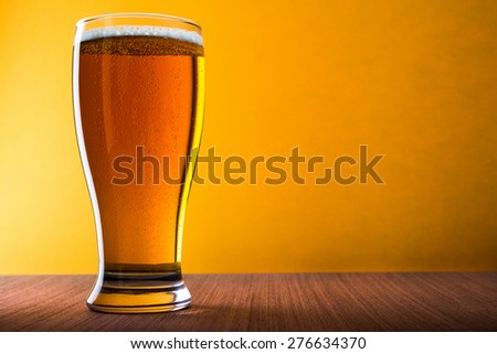 Mug of light beer on wooden table