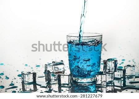 Poured water into glass on white background