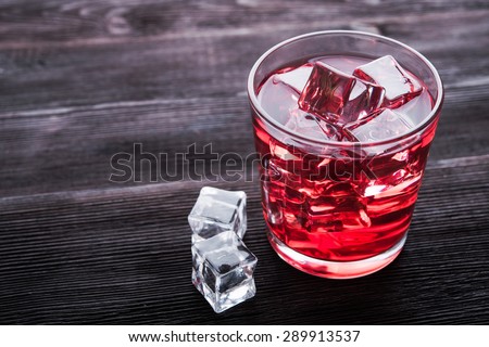 Cherry cider in glass with ice cubes