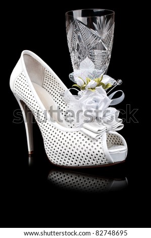 crystal goblet and wedding shoe isolated on a black background