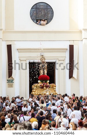 MALAGA, SPAIN - JULY 16: Unidentified local worshippers lift a religious image out of the church during the \'Virgen del Carmen\' procession on July 16, 2012 in Malaga, Spain.