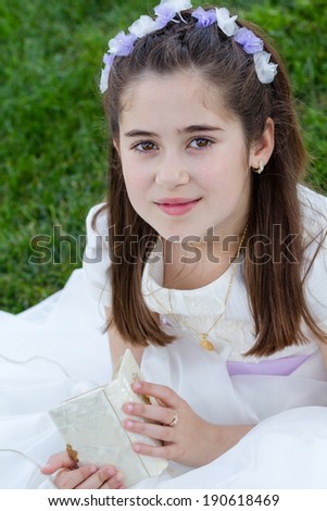 A young girl with prayer book celebrating her First Holy Communion