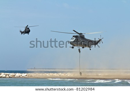 MALAGA, SPAIN - MAY 28: Unidentified soldiers descend from a Sea King helicopter of the Spanish Navy at Malagueta Beach during the Spanish Armed Forces Day on May 28, 2011 in Malaga, Spain.
