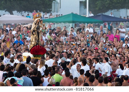 MALAGA, SPAIN - JULY 16: Unidentified local worshipers lift a religious image at the beach during the \'Virgen del Carmen\' festival on July 16, 2011 in Malaga, Spain.