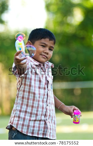asian boy playing balloon gun toy