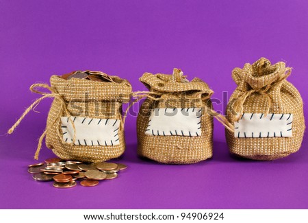 Three sacks full of coins over purple background