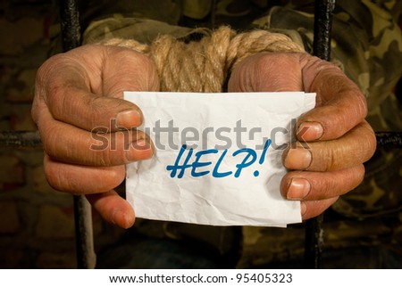 Man with hands tied up with chain holding a piece of paper