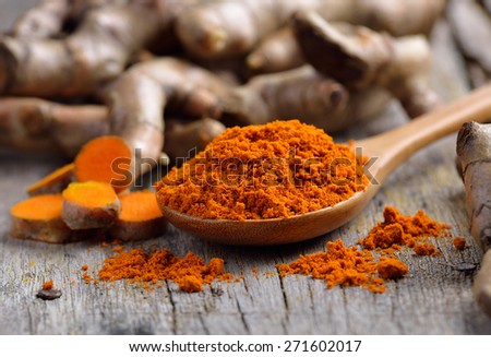 pile of fresh turmeric roots on wooden table