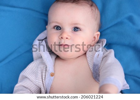 Blue Eyed Baby Boy on a Blue Blanket Looking at the Camera