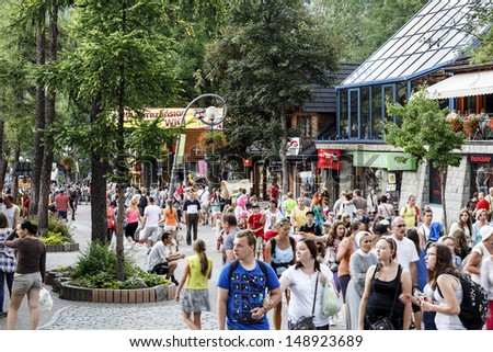 ZAKOPANE - JULY 23: Unidentified tourists crowded site visits at the Krupowki street, the main shopping area and pedestrian promenade in the city center  in Zakopane in Poland on July 23, 2013