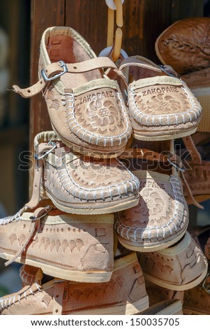 ZAKOPANE - JULY 22: Handmade Shoes made of leather, decorated with the local traditional way put on sale at the local market in Zakopane in Poland on July 22, 2013