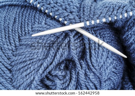 Woolen thread and knitting needle shown closeup