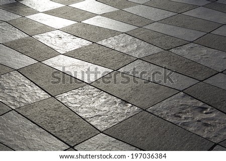Detail of pavement built of white and black stone slabs on the Massena Square in the city of Nice, France