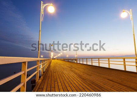 JURATA, POLAND - SEPTEMBER 11, 2014: Night view of Wooden Pier with a length of 320 meters, built in the 70s of the 20th century, located at the Baltic Sea coast at the waters of the Gulf of Puck