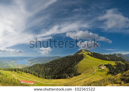 Beautiful panorama Alps mountains with lake in valley and clouds on background
