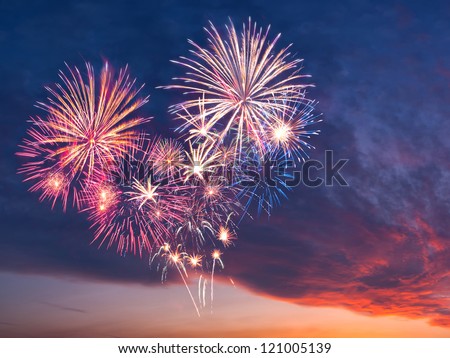 Beautiful colorful holiday fireworks in the evening sky with majestic clouds,  long exposure