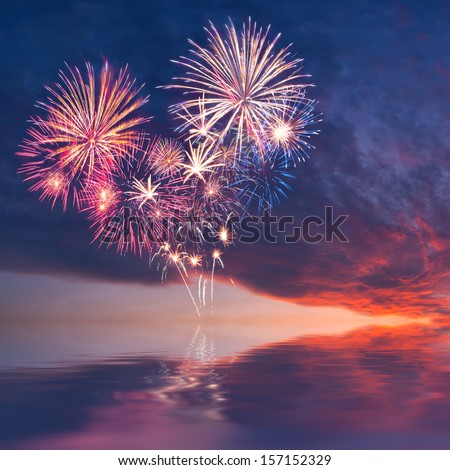 Fireworks in the sky in the form of heart reflection in water