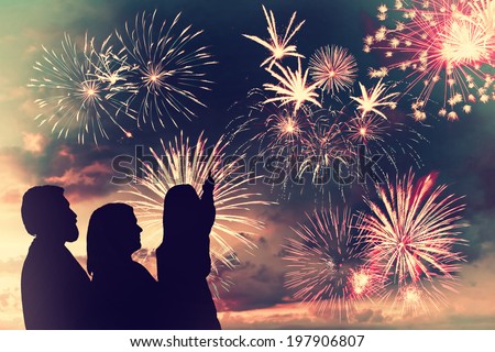 The happy family looks holiday fireworks in the evening sky