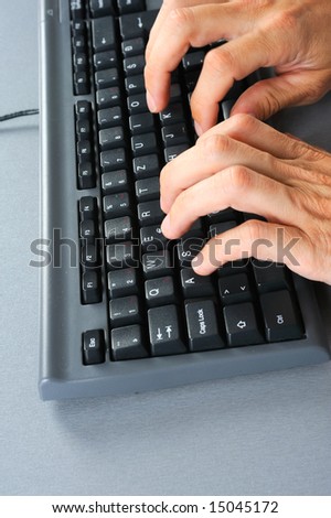 human fingers over computer keyboard while typing