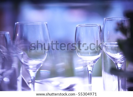 Empty glasses on restaurant table lit with purple light